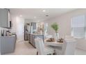 Bright, open-concept kitchen and dining area with modern finishes and stainless steel appliances at 2959 Waterlily Way, Poinciana, FL 34759