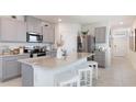 Modern kitchen with stainless steel appliances, granite countertops, and a stylish center island with seating at 2959 Waterlily Way, Poinciana, FL 34759