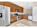 Well-equipped kitchen with stainless steel appliances, wooden cabinets, and tile flooring at 2975 White Cedar Cir, Kissimmee, FL 34741