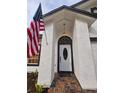 Close-up of a front door and textured siding with an American flag at 3146 Byington Terrace Ter, Deltona, FL 32738