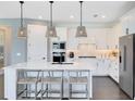 Beautiful kitchen boasts white cabinetry, stainless steel appliances, and an island with seating at 3361 Orange Rose Loop, Apopka, FL 32712