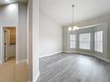 Airy living room with gray floors, large windows, and a view to the laundry room at 404 Wilshire Dr, Casselberry, FL 32707