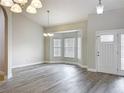 Bright, open living room featuring sleek gray floors, a bay window, and elegant chandeliers at 404 Wilshire Dr, Casselberry, FL 32707
