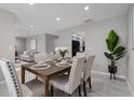 Dining room with a wooden table, seating for six, and modern decor, creating an inviting space for meals at 4161 Leafy Glade Pl, Casselberry, FL 32707
