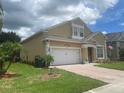 Charming two-story home with a well-maintained lawn, brick paved driveway, and an attached two-car garage at 447 Cadiz Loop, Davenport, FL 33837
