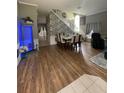 Open-concept living and dining area boasts sleek hardwood floors and a staircase with modern accents at 447 Cadiz Loop, Davenport, FL 33837