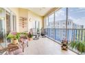 Relaxing screened balcony with seating, tile floor, and coastal-themed decor offers a charming outdoor living space at 5300 S Atlantic Ave # 6-502, New Smyrna Beach, FL 32169