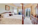 Spacious main bedroom featuring a four-poster bed, ceiling fan, and balcony access for a luxurious retreat at 5300 S Atlantic Ave # 6-502, New Smyrna Beach, FL 32169