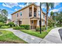 Well-maintained townhome with lush landscaping, a charming balcony, and sidewalk at 5464 Factors Walk Dr, Sanford, FL 32771