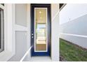 Stylish blue-framed glass front door offering a glimpse of the home's interior at 667 Pennywort St, Lake Alfred, FL 33850
