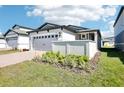 Beautiful front exterior with green lawn and landscaping, featuring a gray two-car garage at 667 Pennywort St, Lake Alfred, FL 33850