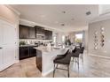Gourmet kitchen with island, dark cabinets, stainless appliances, and bar seating open to the dining area at 7224 Nottingham Reel Ct, St Cloud, FL 34773
