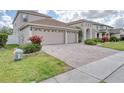 Attractive home with a three car garage, brick paver driveway, and manicured landscaping at 839 Timber Isle Dr, Orlando, FL 32828