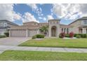 Inviting home with a three car garage, arched entry, and lush, green lawn at 839 Timber Isle Dr, Orlando, FL 32828