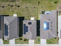 This aerial view showcases neighborhood homes, each with solar panels on the roofs at 942 Jackson Ave, Davenport, FL 33837