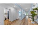 Hallway features wood-look flooring, light blue walls, and doorways to a bathroom and bedroom at 1028 Morfontaine St, Daytona Beach, FL 32124