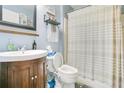Cozy bathroom featuring a wooden vanity, toilet, and a shower with a striped curtain and blue painted walls at 1116 Adirondack St, Deltona, FL 32725