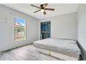 Simple bedroom with light gray walls, ceiling fan, a bed, light gray floors, and a closet at 1116 Adirondack St, Deltona, FL 32725