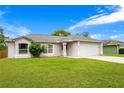 Inviting single-story home featuring a green lawn, neutral exterior paint, and an attached two-car garage at 1116 Adirondack St, Deltona, FL 32725