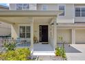 Inviting front porch with seating, lush landscaping, and an entrance to a two-car garage at 14231 Sonco Ave, Windermere, FL 34786