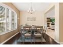 Inviting dining space with wood floors, a modern chandelier, and a view into the cozy living room area at 1428 Lucky Pennie Way, Apopka, FL 32712