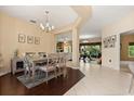Formal dining room featuring a modern chandelier, a neutral color palette, and elegant dark wood floors at 1428 Lucky Pennie Way, Apopka, FL 32712