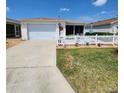 Beautiful home with a well-kept lawn, white picket fence, and a convenient driveway leading to the garage at 16922 Se 81St Charlesfort Ave, The Villages, FL 32162
