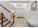 Bright foyer featuring tile flooring, arched doorways and staircase with wood railing at 1778 Waterside Oaks Dr, Orange City, FL 32763