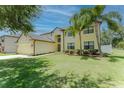 Lovely two-story home boasts a well-maintained lawn, mature trees, and attached garage at 1778 Waterside Oaks Dr, Orange City, FL 32763