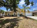 Charming single-story home with a well-manicured lawn, palm tree, and attached two-car garage at 1912 Conch Ln, Kissimmee, FL 34759