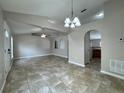 Open-concept living room featuring neutral paint, tile floors, a ceiling fan, and arched doorways at 1912 Conch Ln, Kissimmee, FL 34759