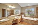 Well-lit primary bathroom boasts a soaking tub, walk-in shower, and double sink vanity at 2019 Wintermere Pointe Dr, Winter Garden, FL 34787