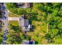 Birds eye view shows a beautiful property with a well-kept lawn, surrounded by lush greenery and mature trees at 2049 Eldorado Ct, St Cloud, FL 34771