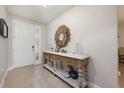 Bright foyer showcasing decorative table and mirror, with the front door offering natural light at 217 Victoria Trails Blvd, Deland, FL 32724
