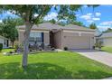 A well-maintained home featuring manicured lawn, a cozy front patio, and a two-car garage at 2217 Caledonian St, Clermont, FL 34711