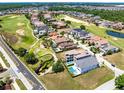 Aerial view of a residential neighborhood with well-maintained homes, lush green golf course and scenic ponds at 300 Muirfield Loop, Reunion, FL 34747