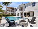 Spacious backyard with a pool, spa, fire pit, and outdoor seating, perfect for relaxation and entertainment at 300 Muirfield Loop, Reunion, FL 34747
