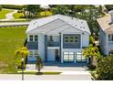 Striking two-story home boasting a stone facade, balcony with hanging chair, a glass paneled two-car garage, and manicured landscaping at 300 Muirfield Loop, Reunion, FL 34747