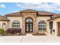 Elegant front entrance with beautiful stone work and landscaping at 35651 Huff Rd, Eustis, FL 32736