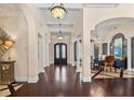 Grand foyer featuring dark hardwood floors, arched entryways, and views into the dining and living rooms at 5909 Oxford Moor Blvd, Windermere, FL 34786