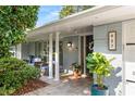 Inviting front porch with brick flooring, classic columns, and seating area at 627 Darcey Dr, Winter Park, FL 32792