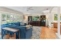 Bright living room featuring a comfortable blue sectional, hardwood floors, and abundant natural light at 627 Darcey Dr, Winter Park, FL 32792
