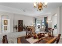 Dining room featuring a chandelier and carpet floors with a view of the living room at 7288 Winding Lake Cir, Oviedo, FL 32765