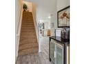 Bright entryway with a staircase, tiled floors, and decorative display, creates an inviting transition to the living spaces at 7663 Fitzclarence St, Kissimmee, FL 34747
