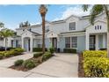 Townhome complex features light blue paint, white trim, and well-manicured landscaping, creating a clean and inviting atmosphere at 7663 Fitzclarence St, Kissimmee, FL 34747