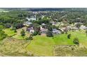 Aerial view showcasing large property with lush green lawn, swimming pool, and nearby pond and tennis courts at 1093 Hidden Harbor Ln, Kissimmee, FL 34746