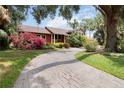 Brick paved driveway with mature landscaping surrounding the attractive two-story home at 1093 Hidden Harbor Ln, Kissimmee, FL 34746