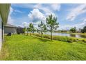 Expansive backyard with a scenic pond view and young pine trees, perfect for outdoor activities and relaxation at 1167 Celery Oaks Ln, Sanford, FL 32771