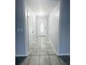 The long hallway has grey ceramic tile at 12112 Shallot St, Orlando, FL 32837
