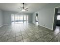 A bright living room features ceramic tile, a ceiling fan, and sliding glass doors at 12112 Shallot St, Orlando, FL 32837